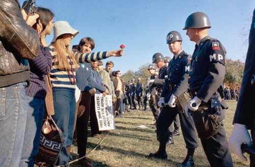 A female demonstrator offers a flower to military police on guard at the Pentagon during an anti-Vietnam demonstration.