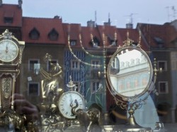 Antique shop window in Poznan with menorah (and central square reflected)