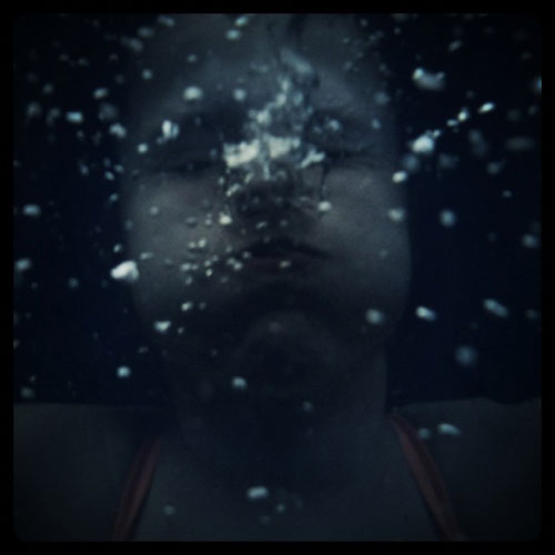 Girl underwater blowing bubbles