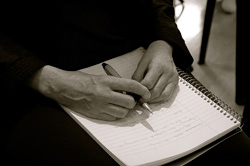 Black and white photo of hands writing